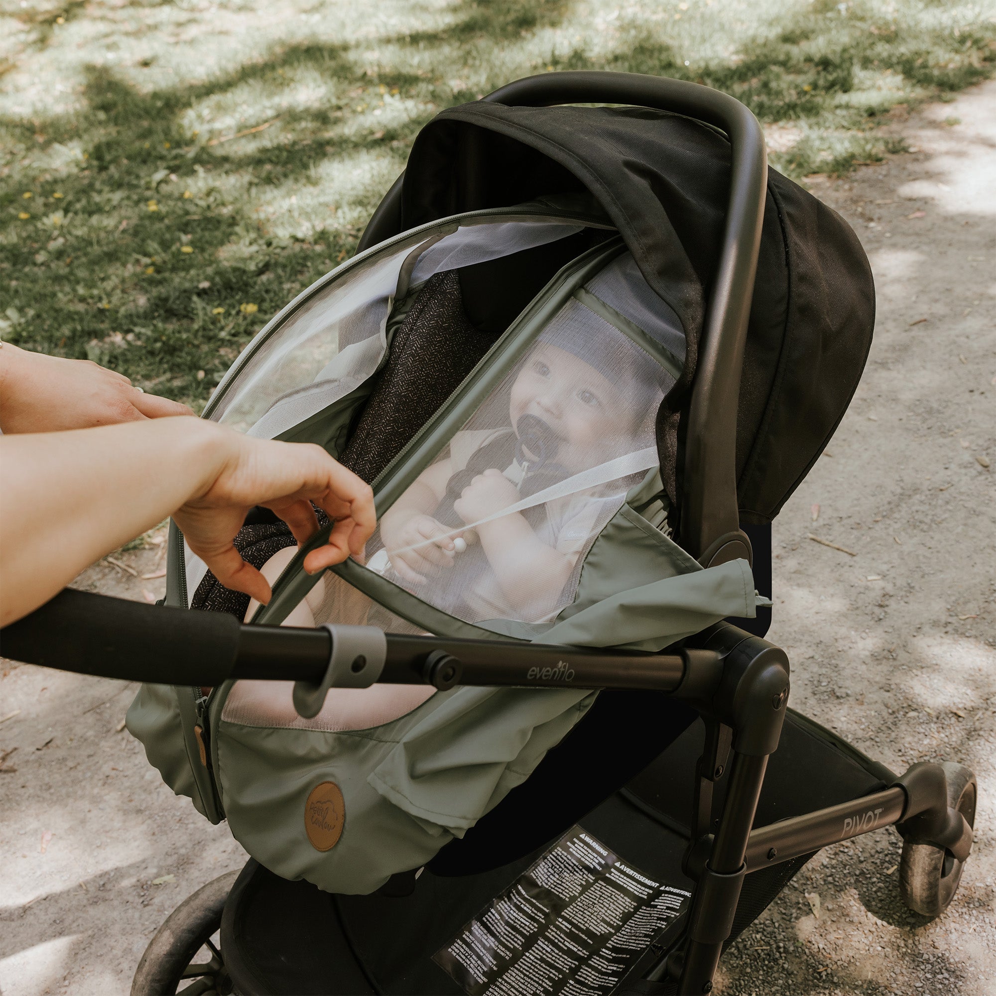 Baby in a car seat with a summer car seat cover sage by Petit Coulou