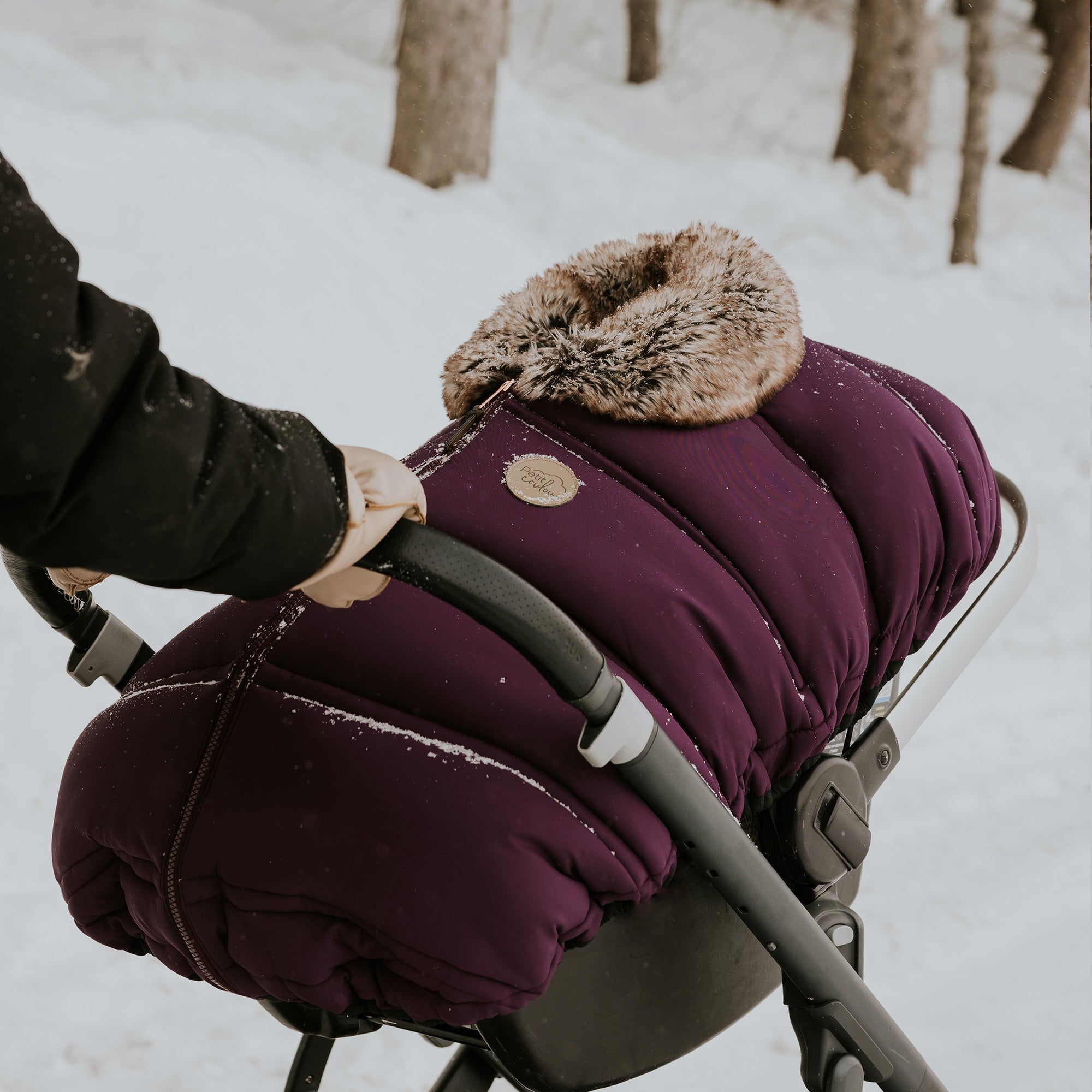 Petit Coulou plum winter cover for baby car seat on a stroller in winter