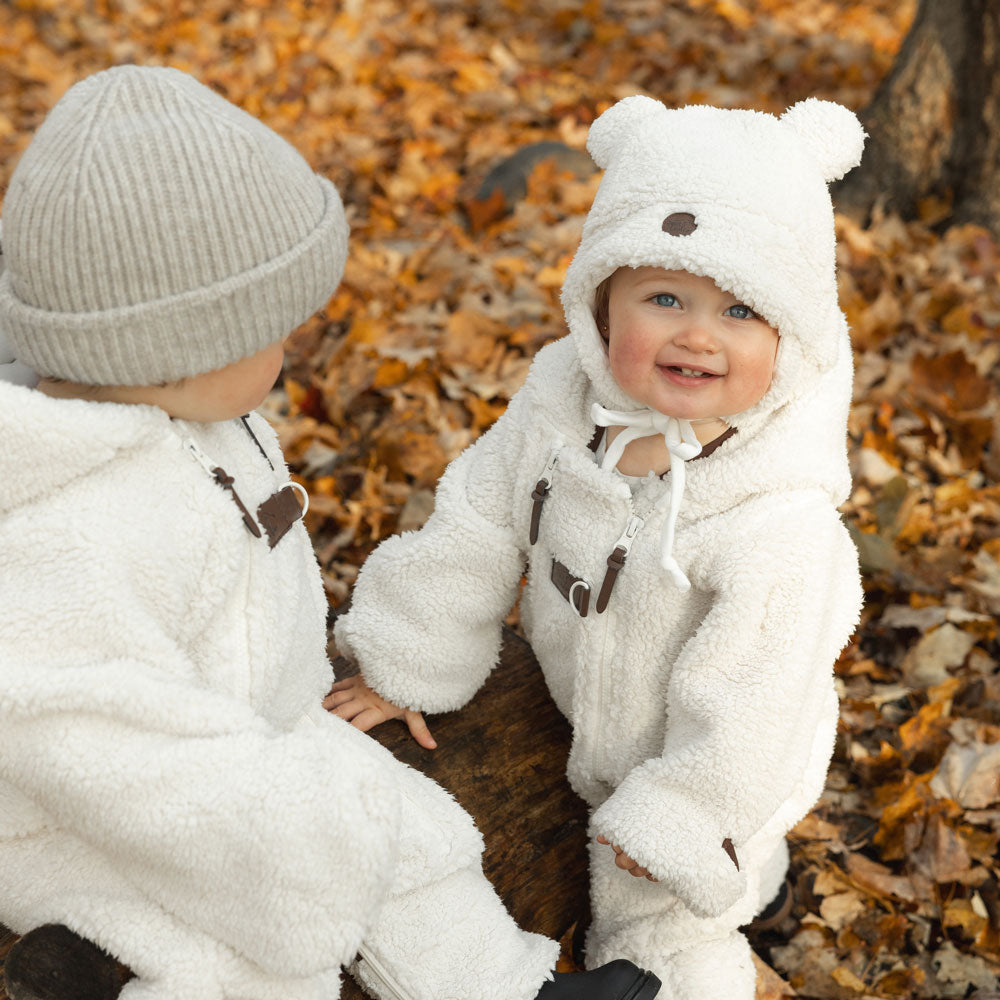 Toddlers with sherpa teddy bear hat and sherpa onesie in autumn