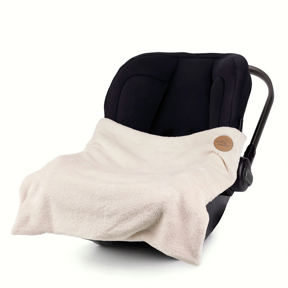 Petit Coulou cream blanket on a baby car seat