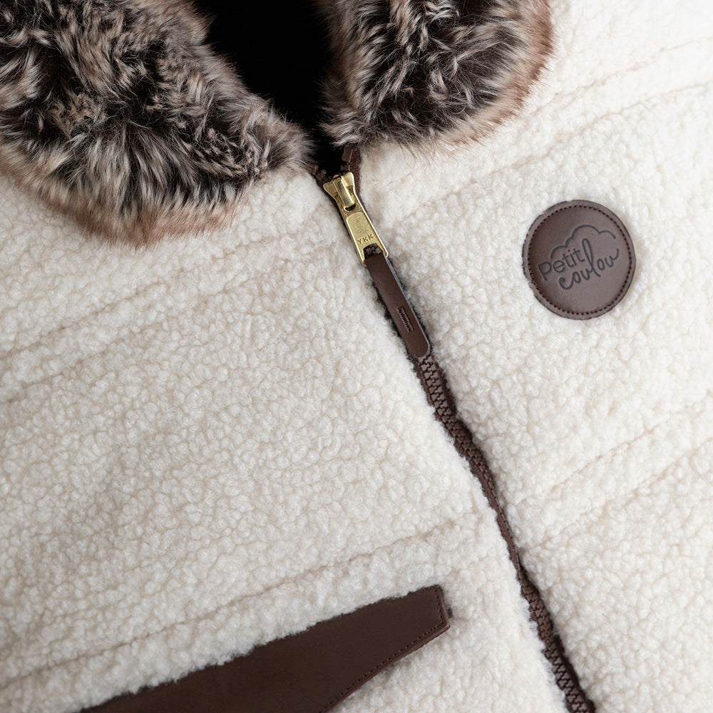 Vue rapprochée de la housse Jasper avec son logo Petit Coulou en cuir synthétique brun foncée et son curseur or