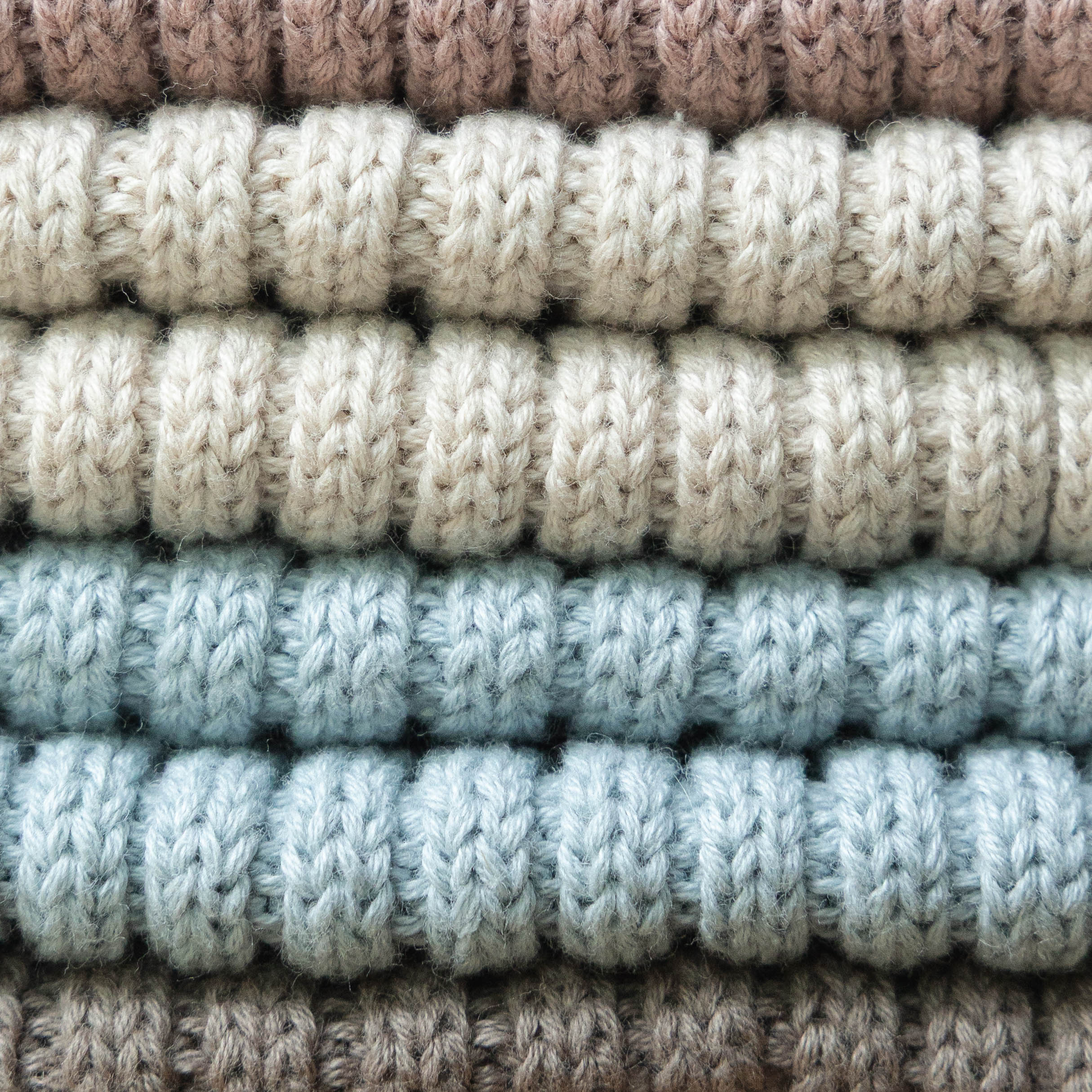 Une photo de très près des 4 couleurs des tuques en tricot Petit Coulou pour bébé
