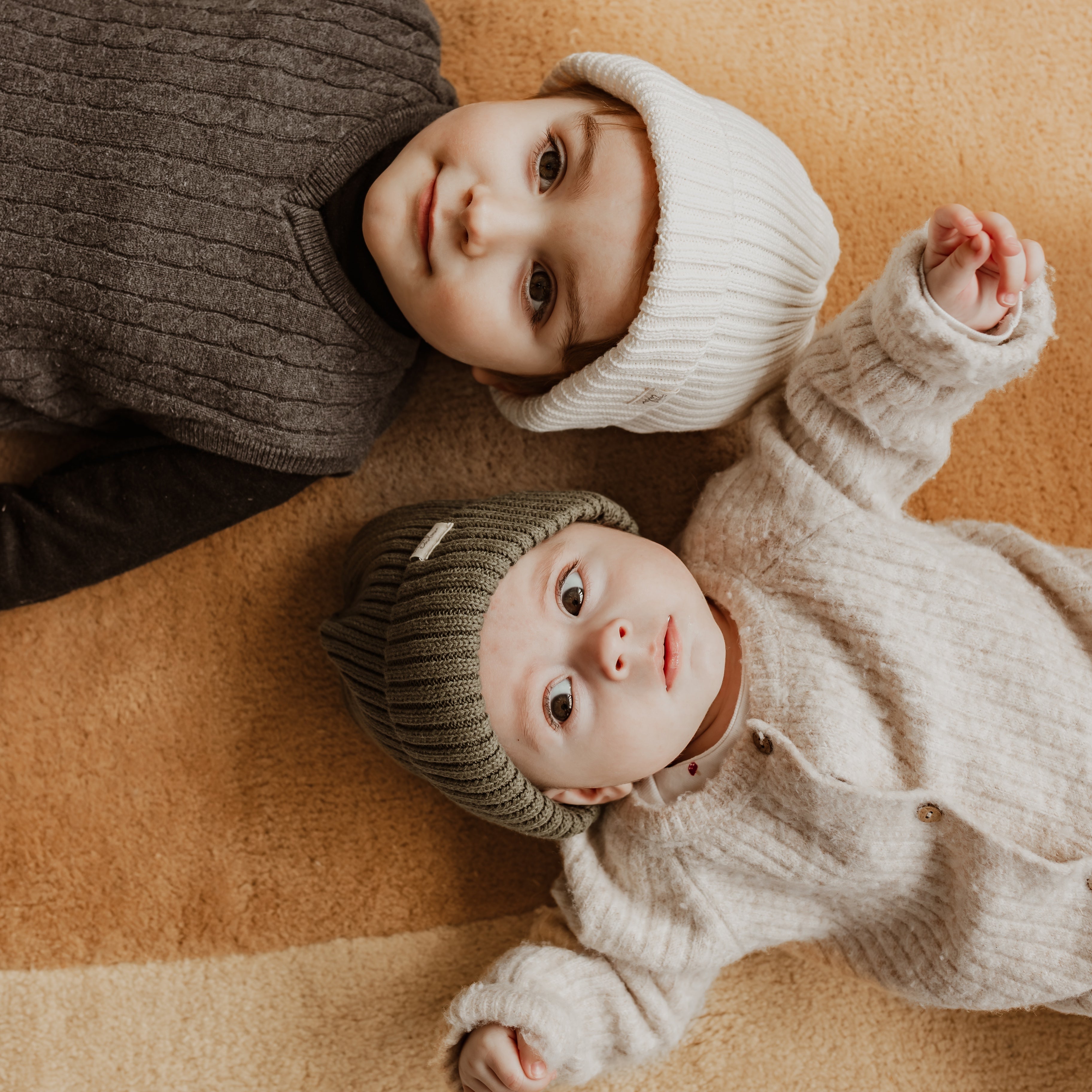 Maman avec bébé dans les bras qui porte les accessoires d'hiver pour nouveau-né Petit Coulou dans la couleur rose