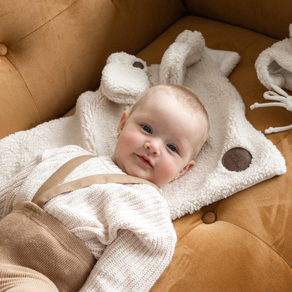Lying baby on a sherpa blanket by Petit Coulou